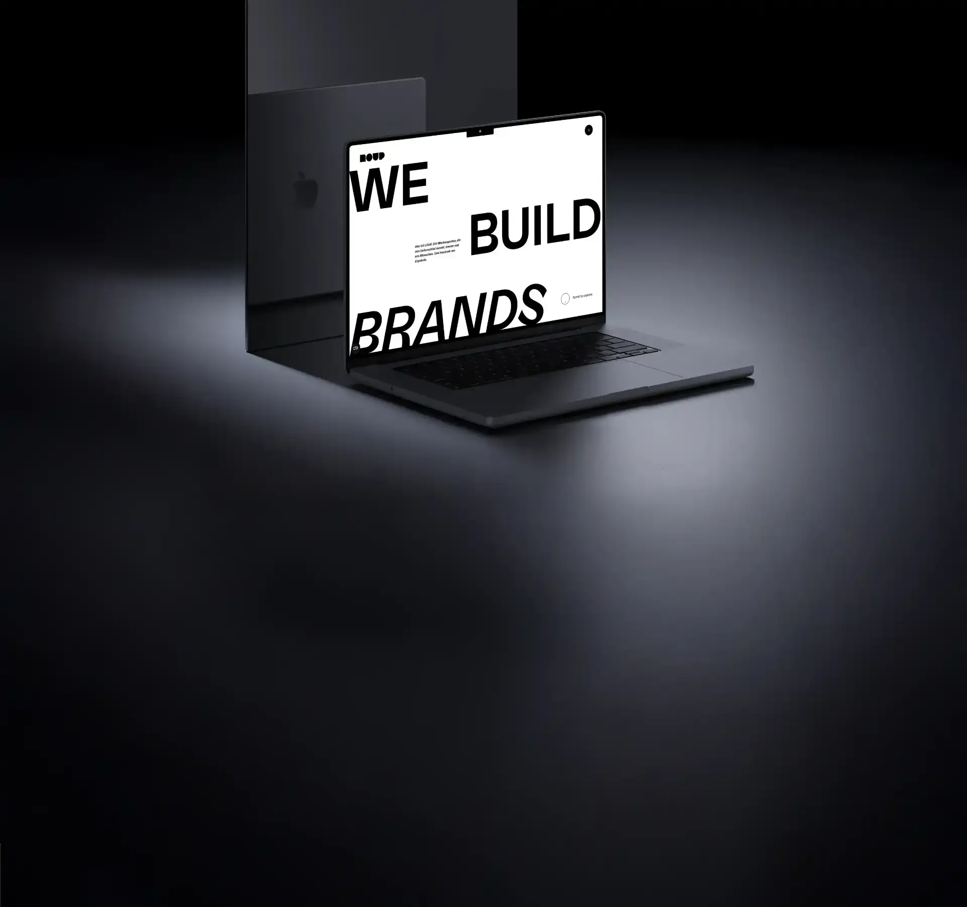 Laptop mit dem Homepage Screen dieser Website und dem Text We build brands in einem dunklen, wertigen Setting